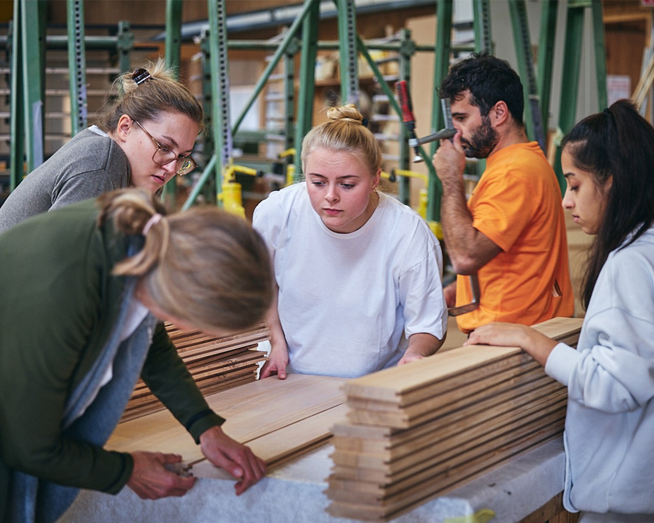 Studierende arbeiten mit Holz