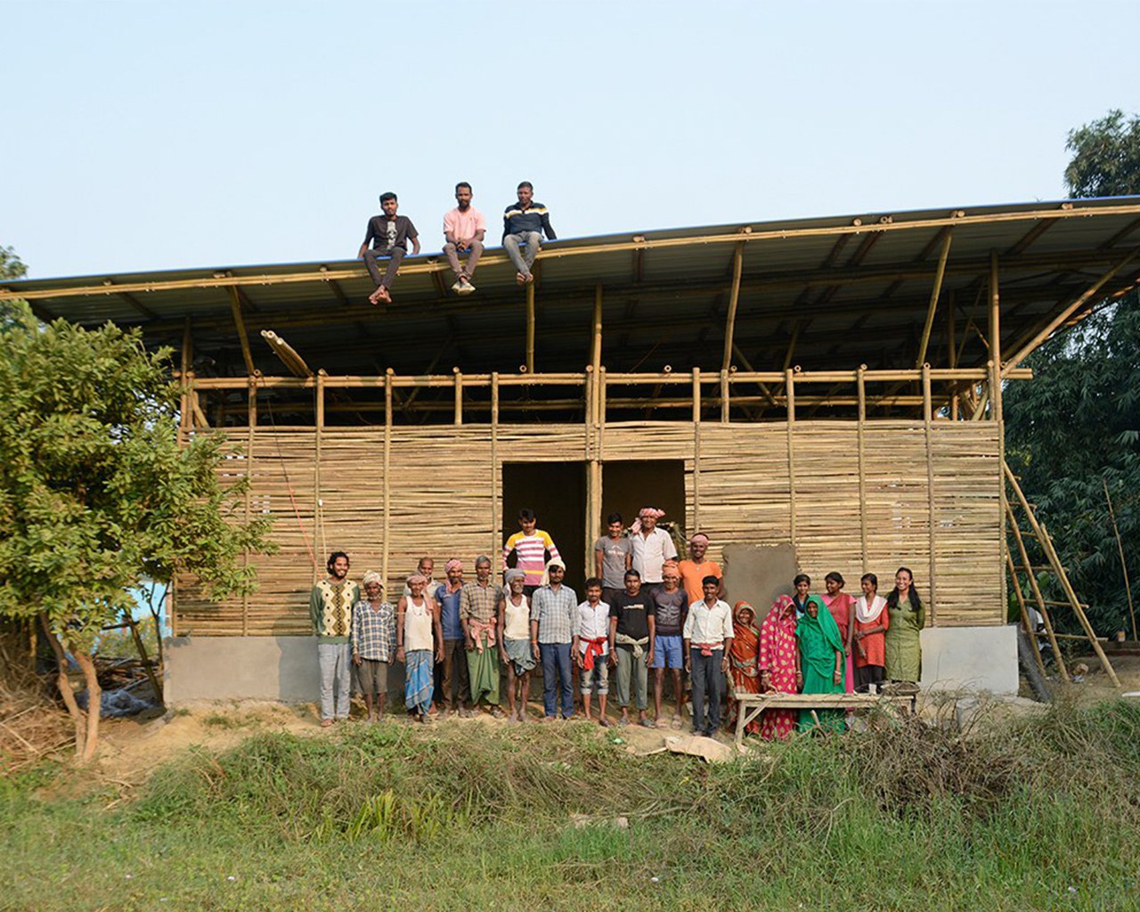 Menschen in Indien, die eine Schule aus Bambus und Lehm bauen