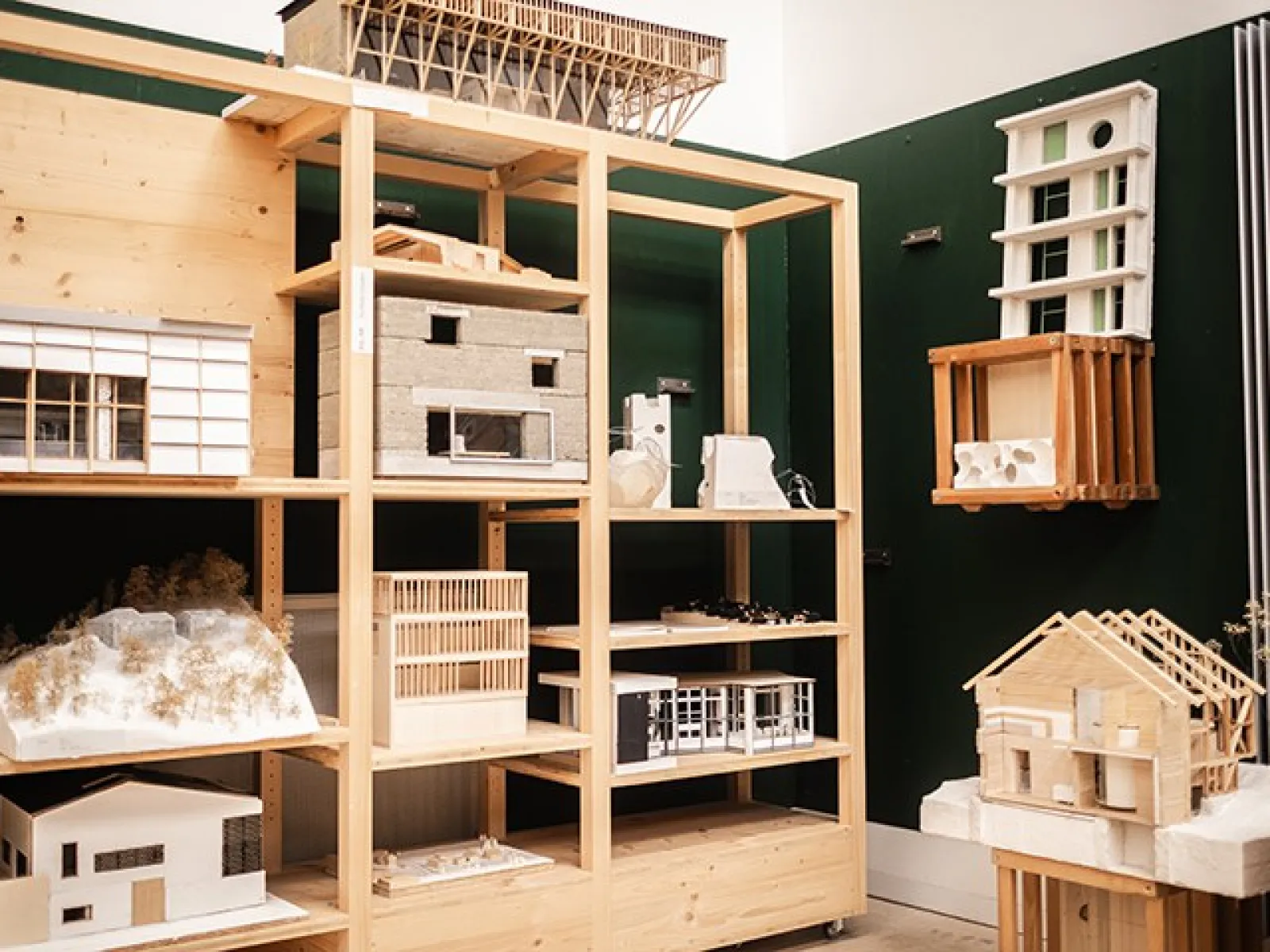 Architekturmodelle in einem Regal in einem Raum der Liechtenstein School of Architecture. Verschiedene Modelle aus Holz und anderen Materialien sind auf mehreren Ebenen ausgestellt.