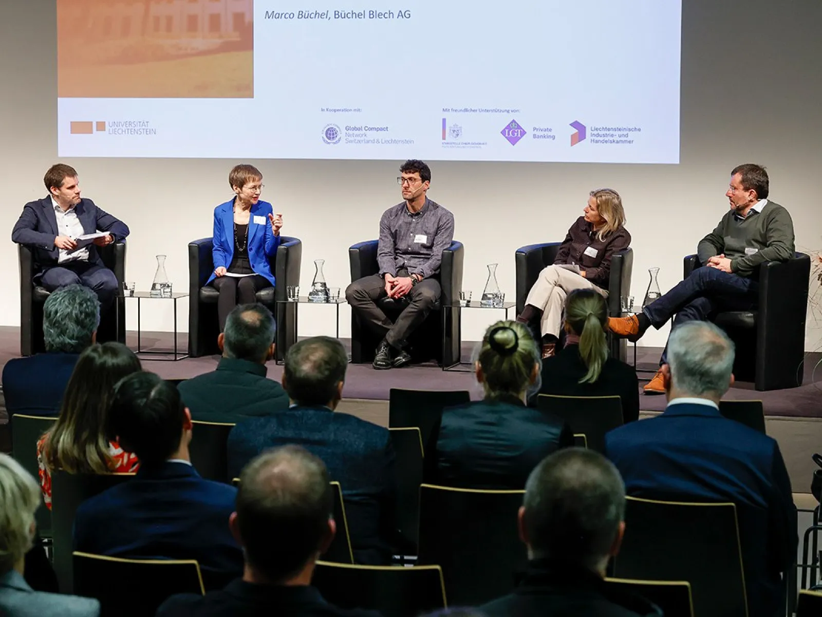 Podiumsdiskussion an der Universität Liechtenstein mit fünf Personen auf einer Bühne, die vor einem Publikum über Nachhaltigkeitsthemen sprechen. Im Hintergrund ist eine Präsentation zu sehen.