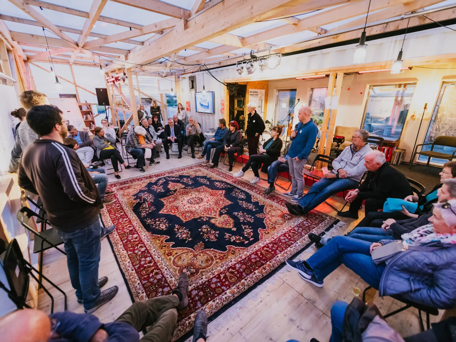 Gruppen von Menschen sitzt in einem Kreis und disktutiert