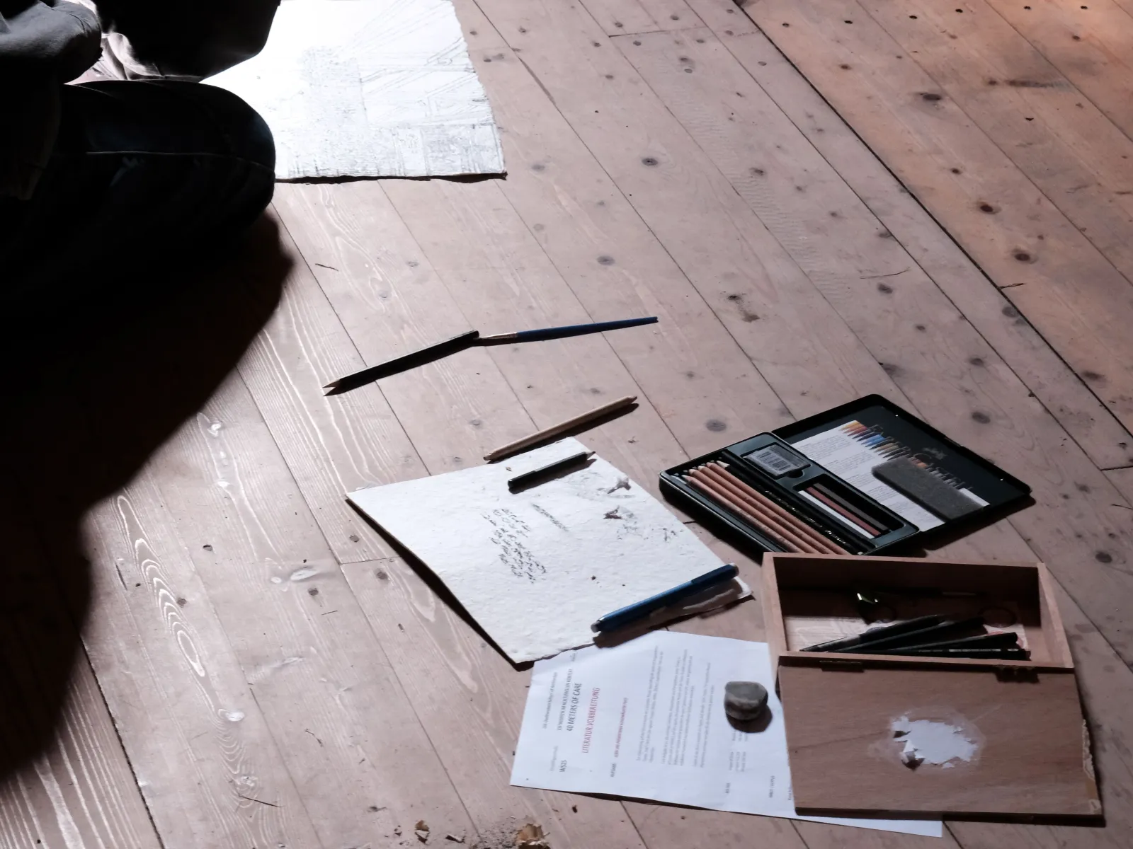 Skizzen und Farben auf einem Holzboden