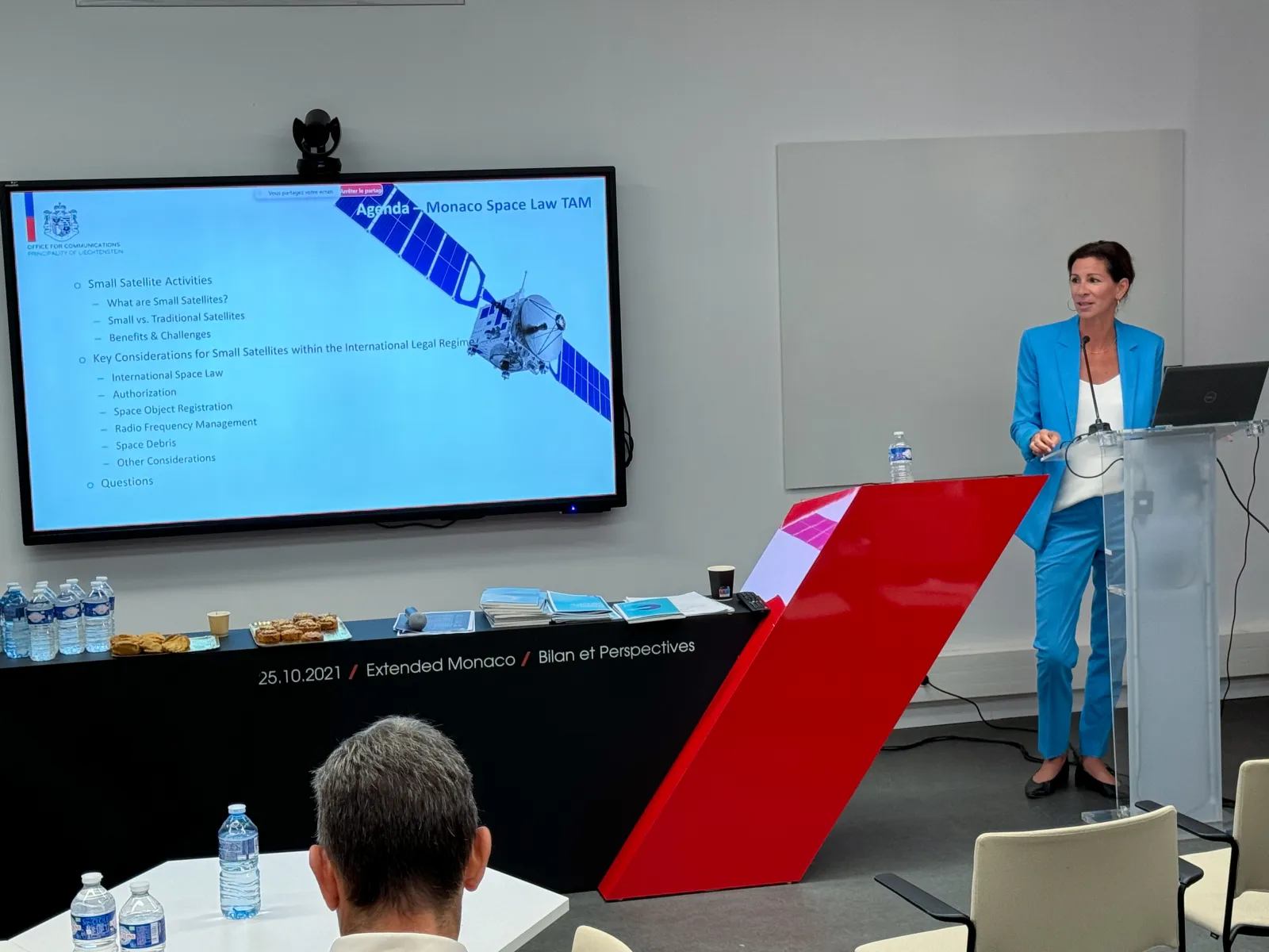 Vortrag zu Space Law mit Präsentationsscreen und Publikum in moderner Seminarumgebung