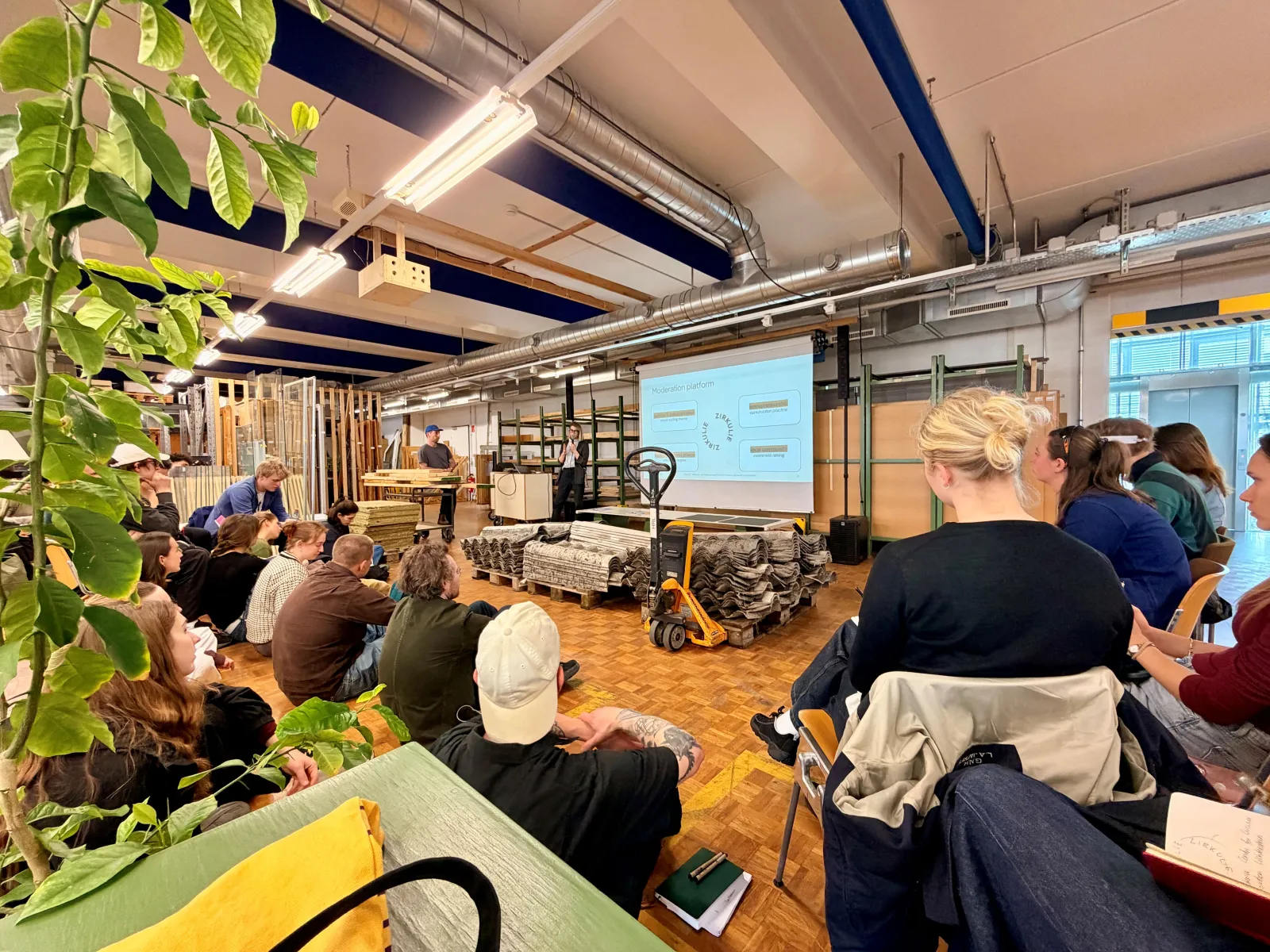 Eine Gruppe junger Menschen lauscht einem Vortrag