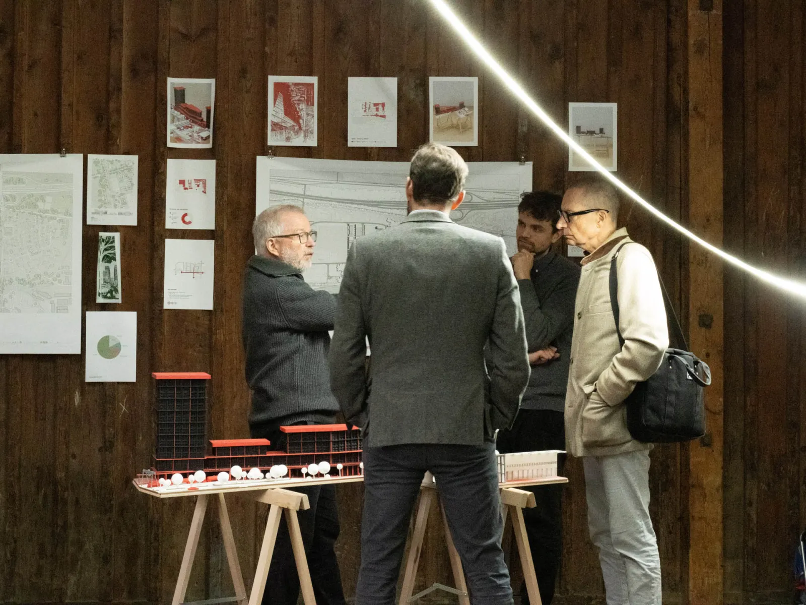 Mehrere Männer unterhalten sich in einer Ausstelllung 