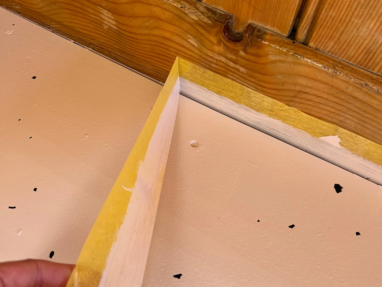 Malerkrepp wird von einer Holzwand abgezogen