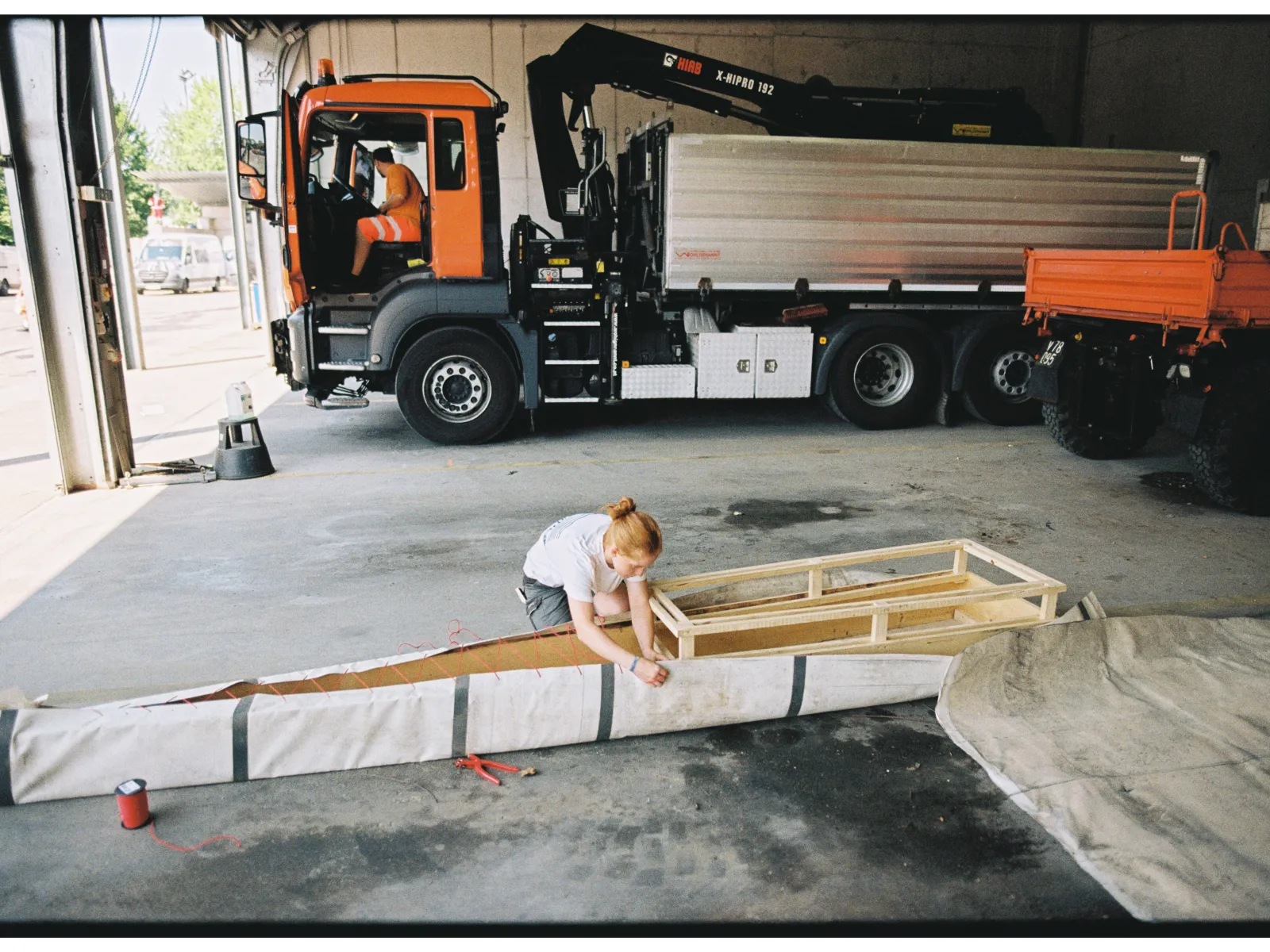 Eine junge Frau arbeitet an einem selbstgebauten Boot. 