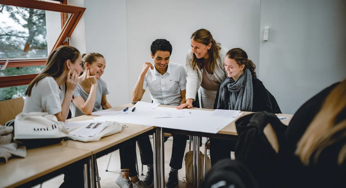 Studierende der Universität Liechtenstein arbeiten gemeinsam an einem Projekt im Seminarraum
