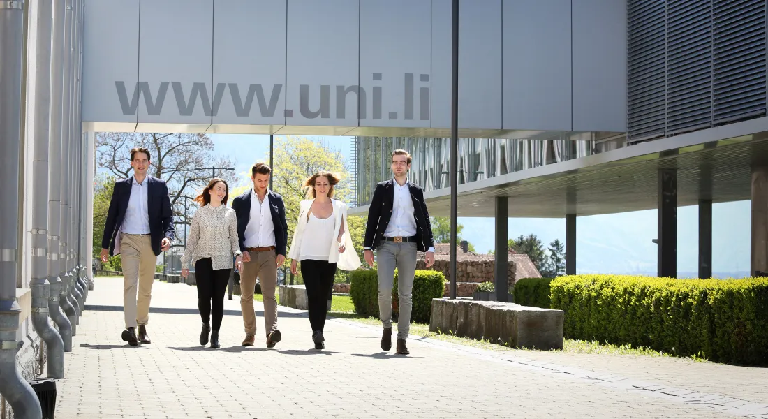 Studierende der Universität Liechtenstein gehen gemeinsam über den modernen Campus in Vaduz
