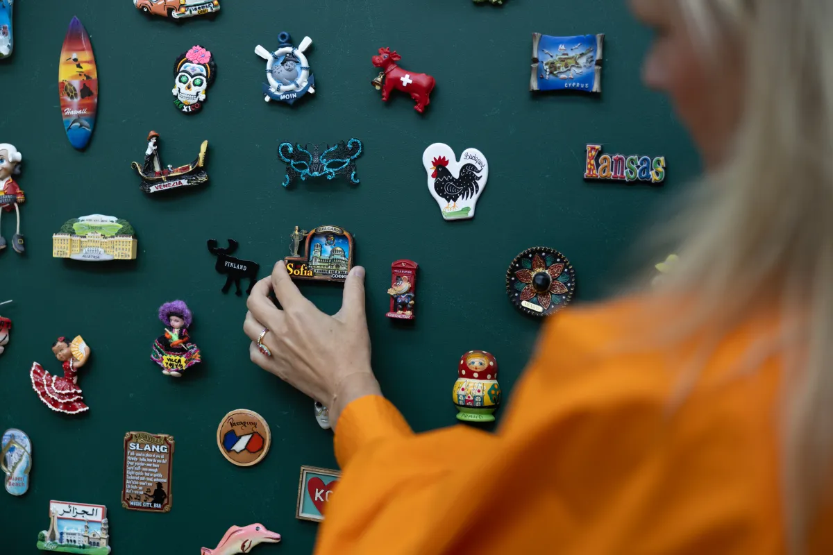 Hand platziert Souvenir-Magnet aus Sofia an Magnetwand.