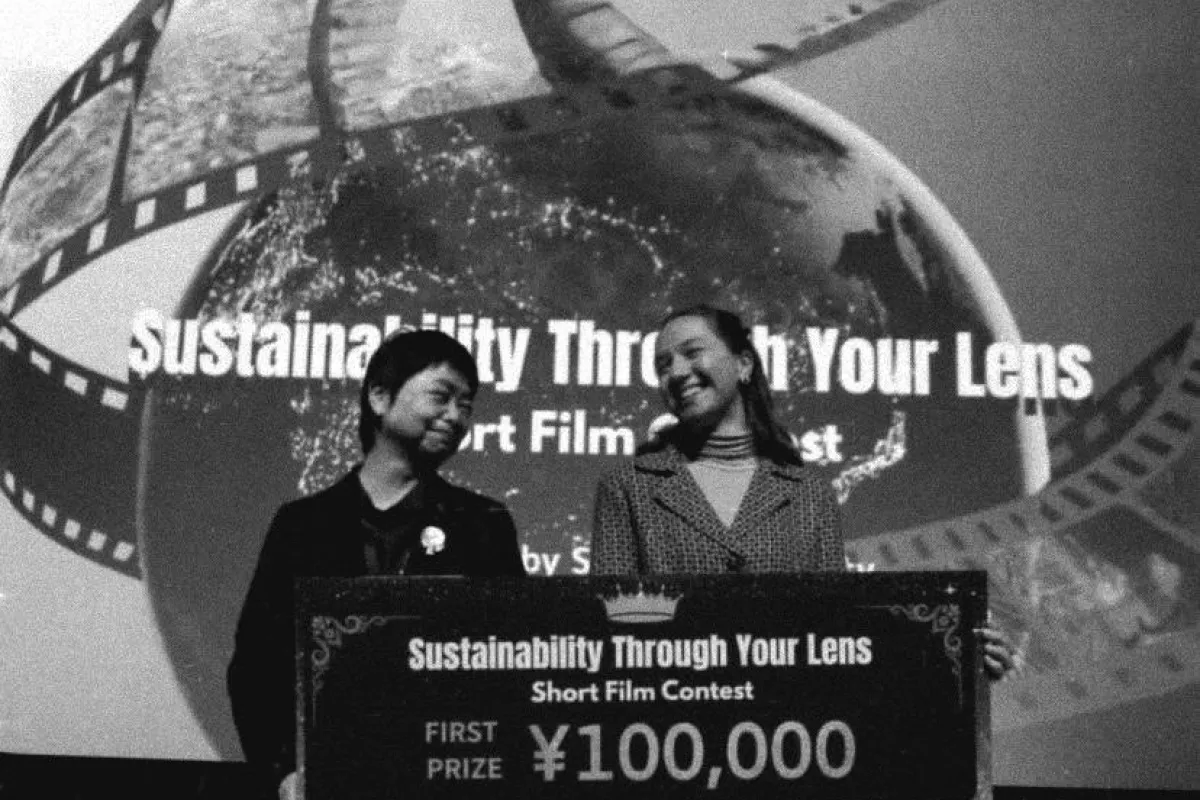 Schwarz-Weiss Aufnahme von zwei Frauen mit einem grossen Scheck in der Hand
