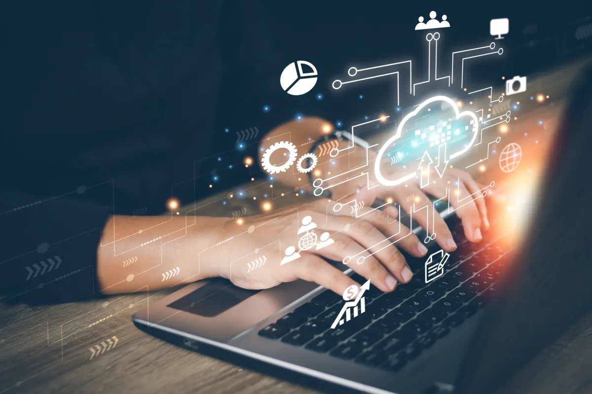 Mann arbeitet am Laptop mit eingefügten Symbolen für Cloud Computing