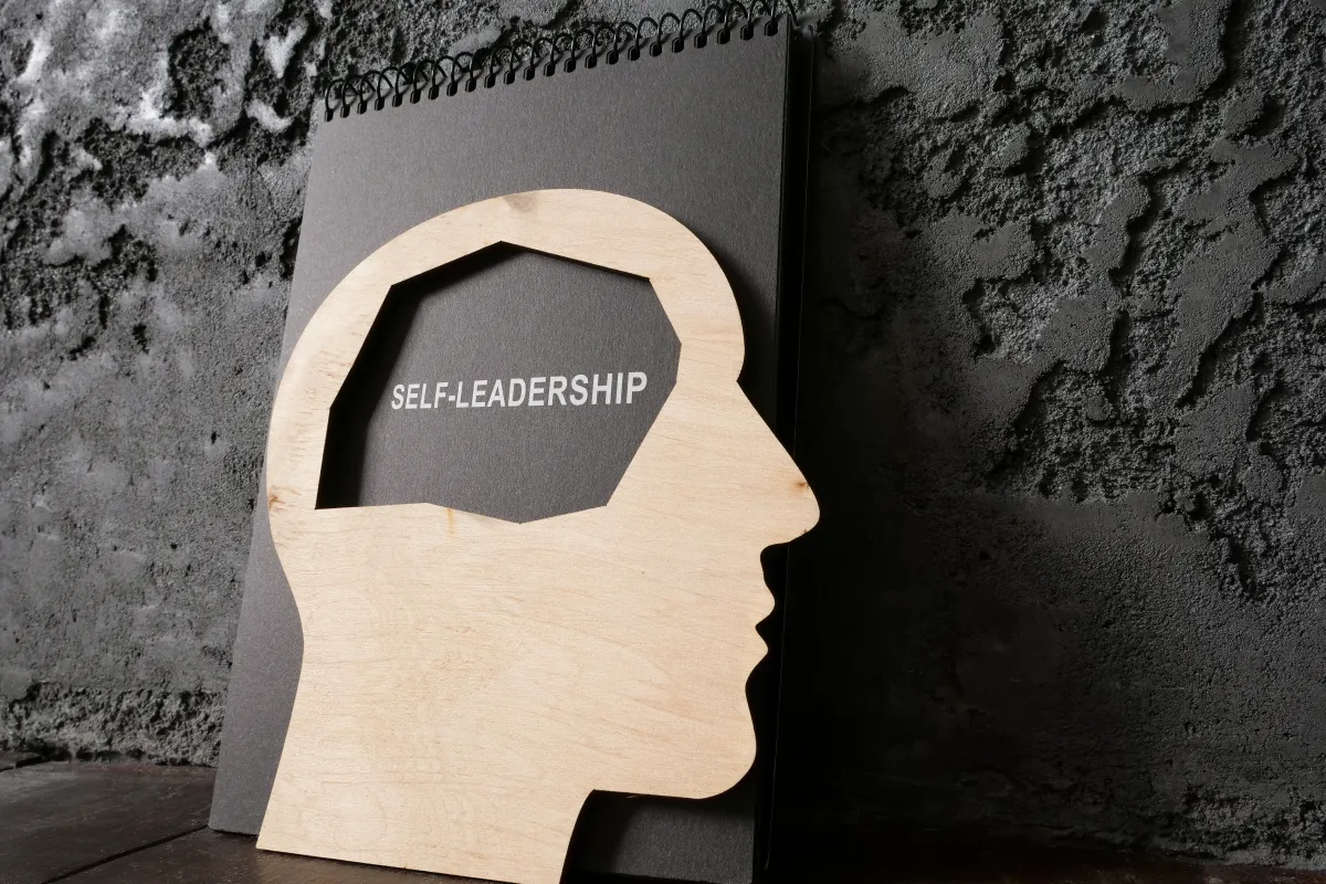 Stilisierter Kopf aus Holz mit Beschriftung Self Leadership