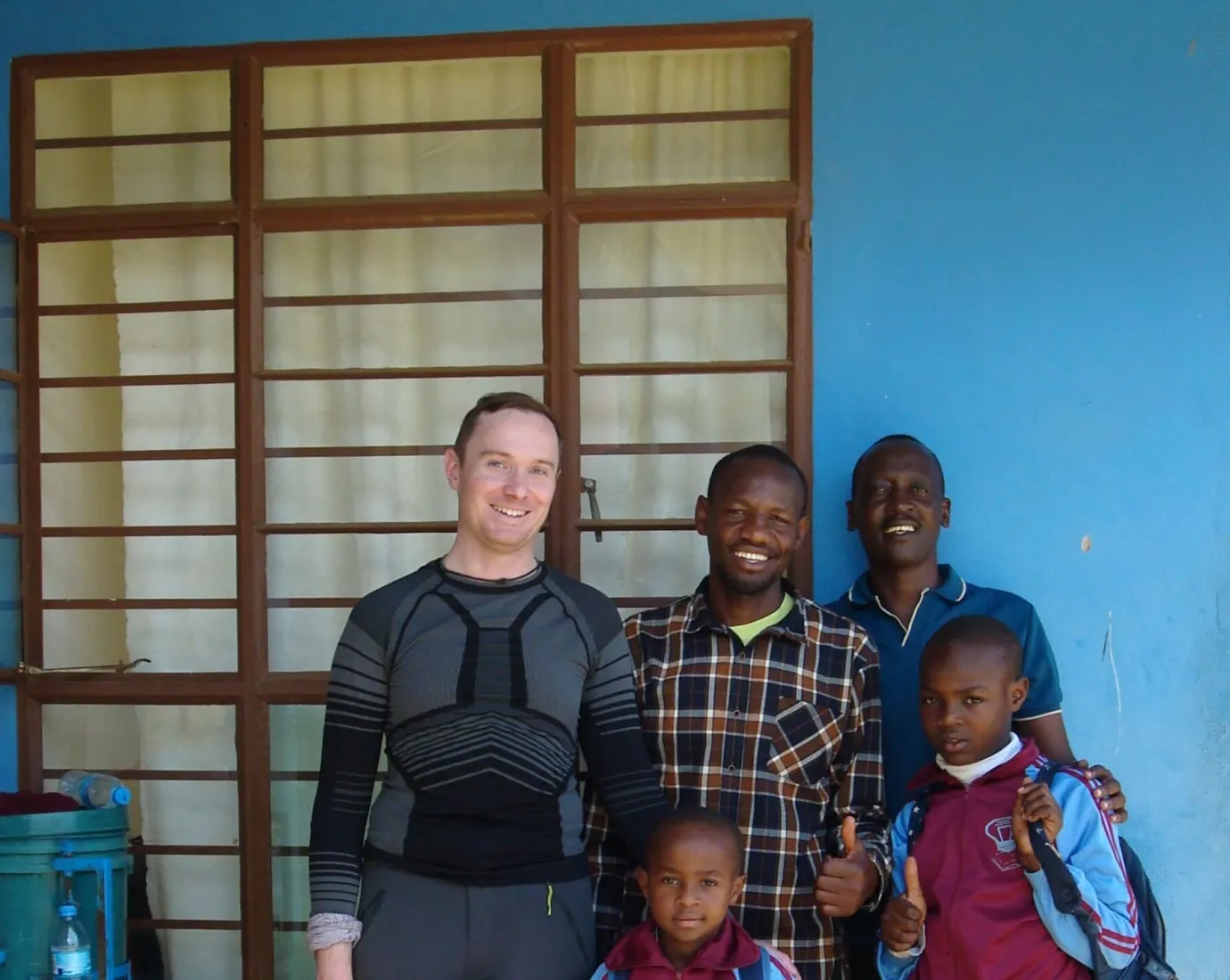 Gruppe von Personen steht vor einem blauen Gebäude.