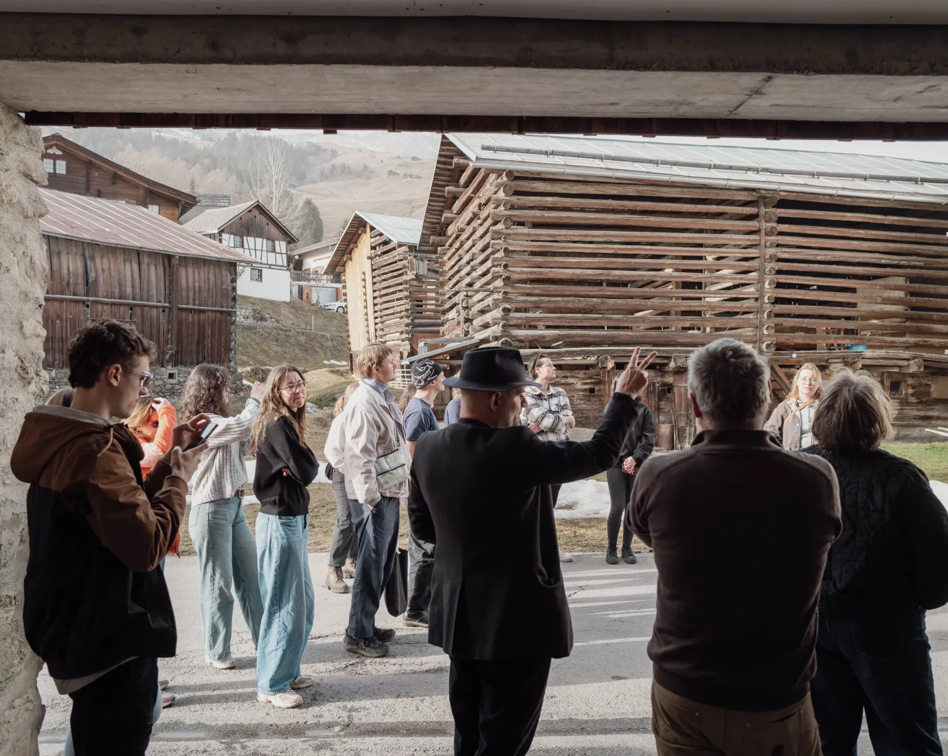 Gruppe von Menschen in einem Dorf mit Holzhäusern