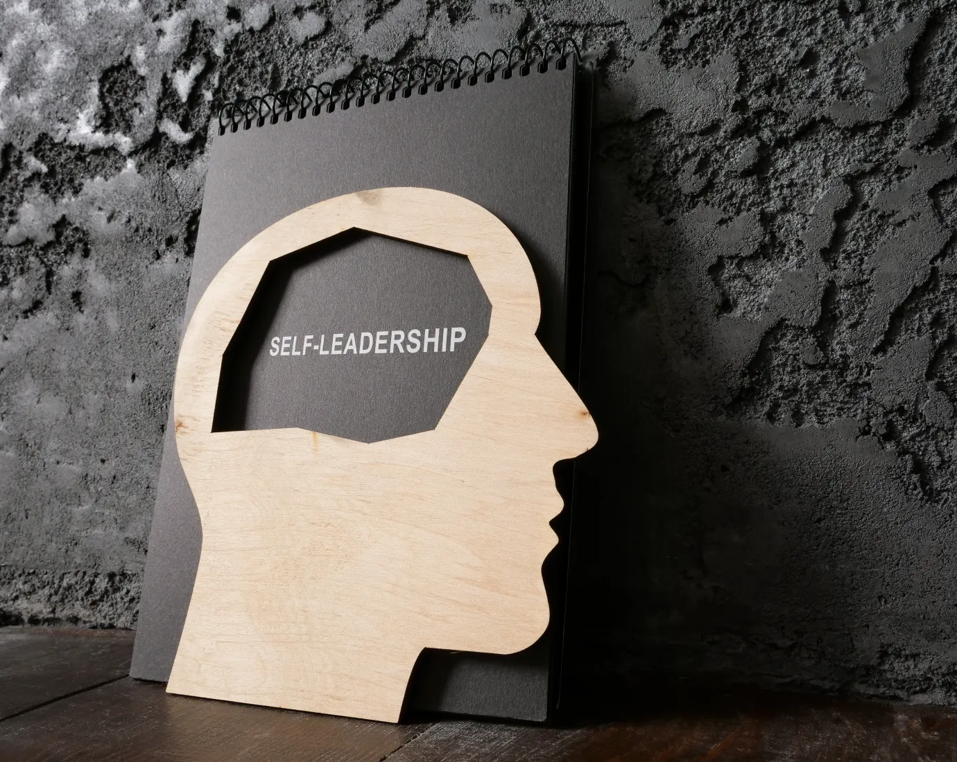 Stilisierter Kopf aus Holz mit Beschriftung Self Leadership