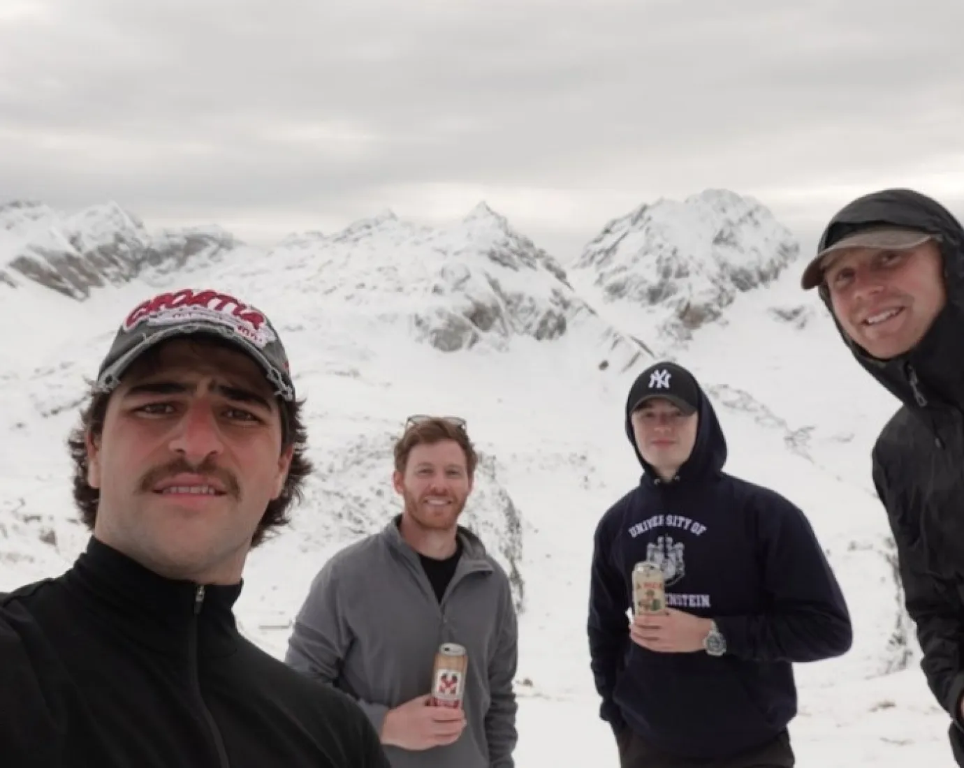 Vier Jungs mit Schneebergen im Hintergrund