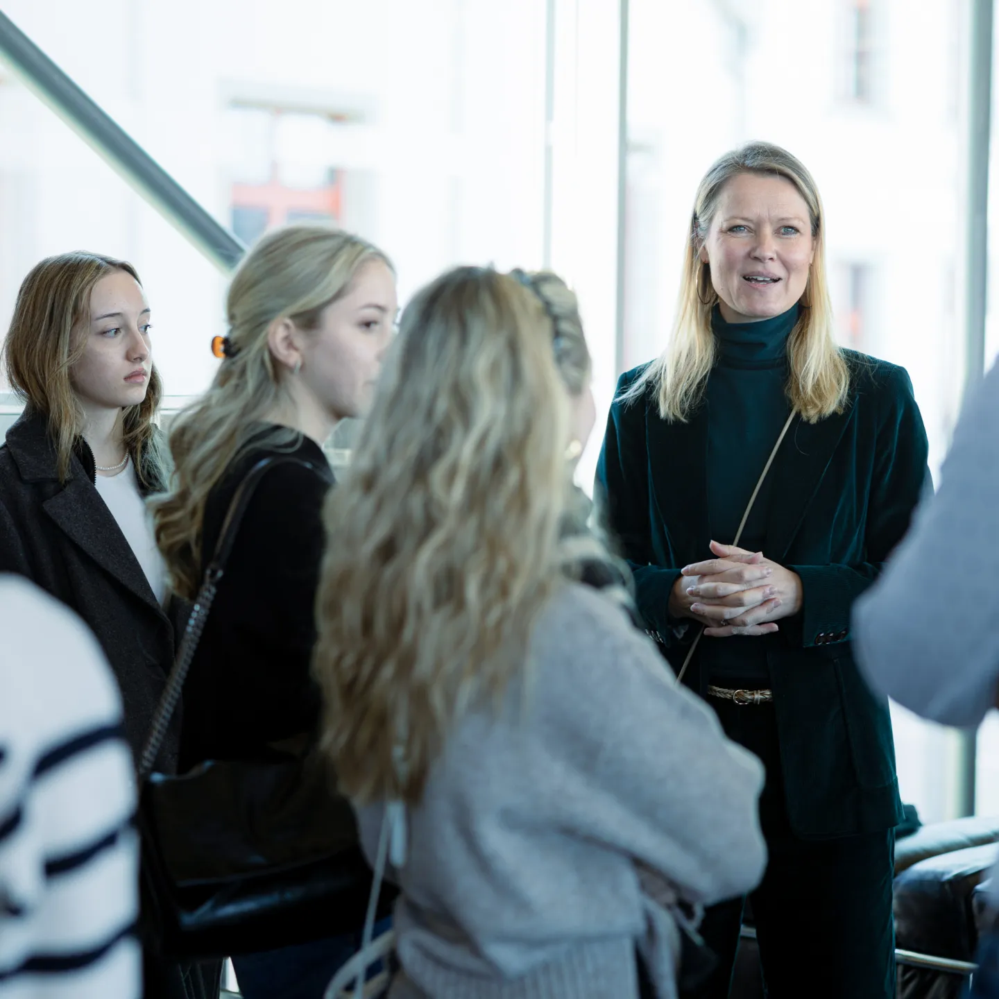 Eine Dozentin der Universität Liechtenstein spricht mit einer Gruppe interessierter Studierender bei einer Campusführung.