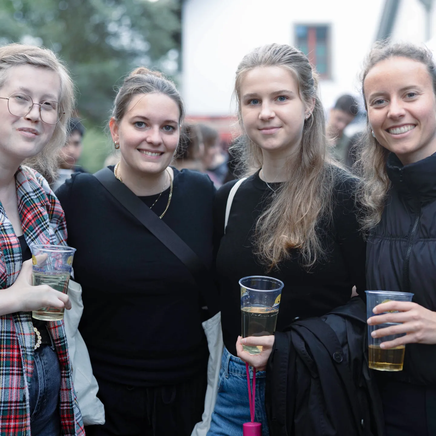 Vier Studentinnen mit Getränken bei einer Outdoor Veranstaltung auf dem Campus der Universität Liechtenstein