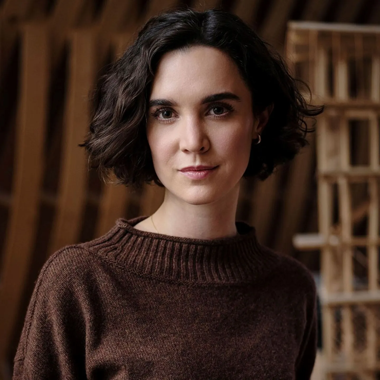 Architektur-Portrait-einer-PhD_Studentin-der-Liechtenstein-School-of-Architecture-mit-Holzmodellen-im-Hintergrund