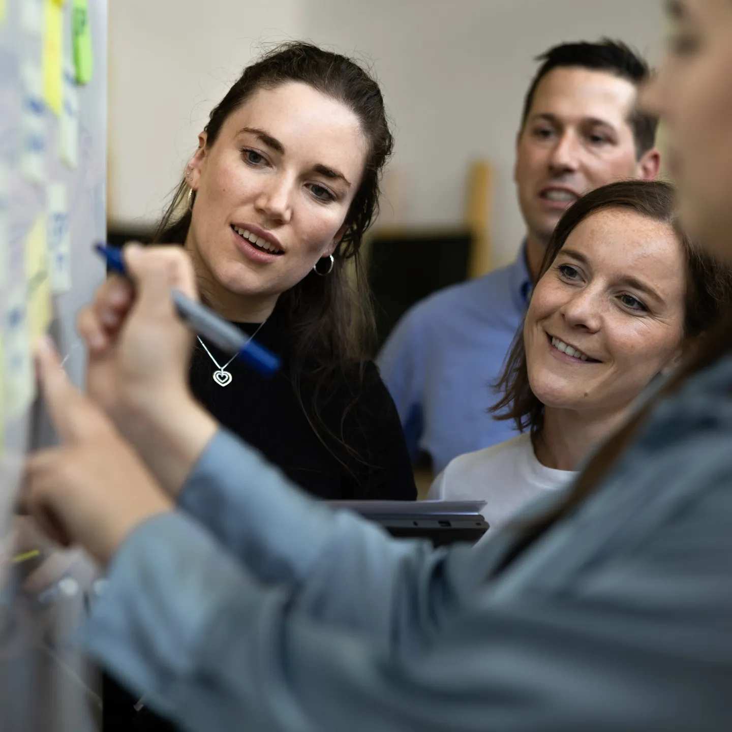 Interaktive Gruppenarbeit mit Post-its an einem Whiteboard im Seminarraum der Universität Liechtenstein.