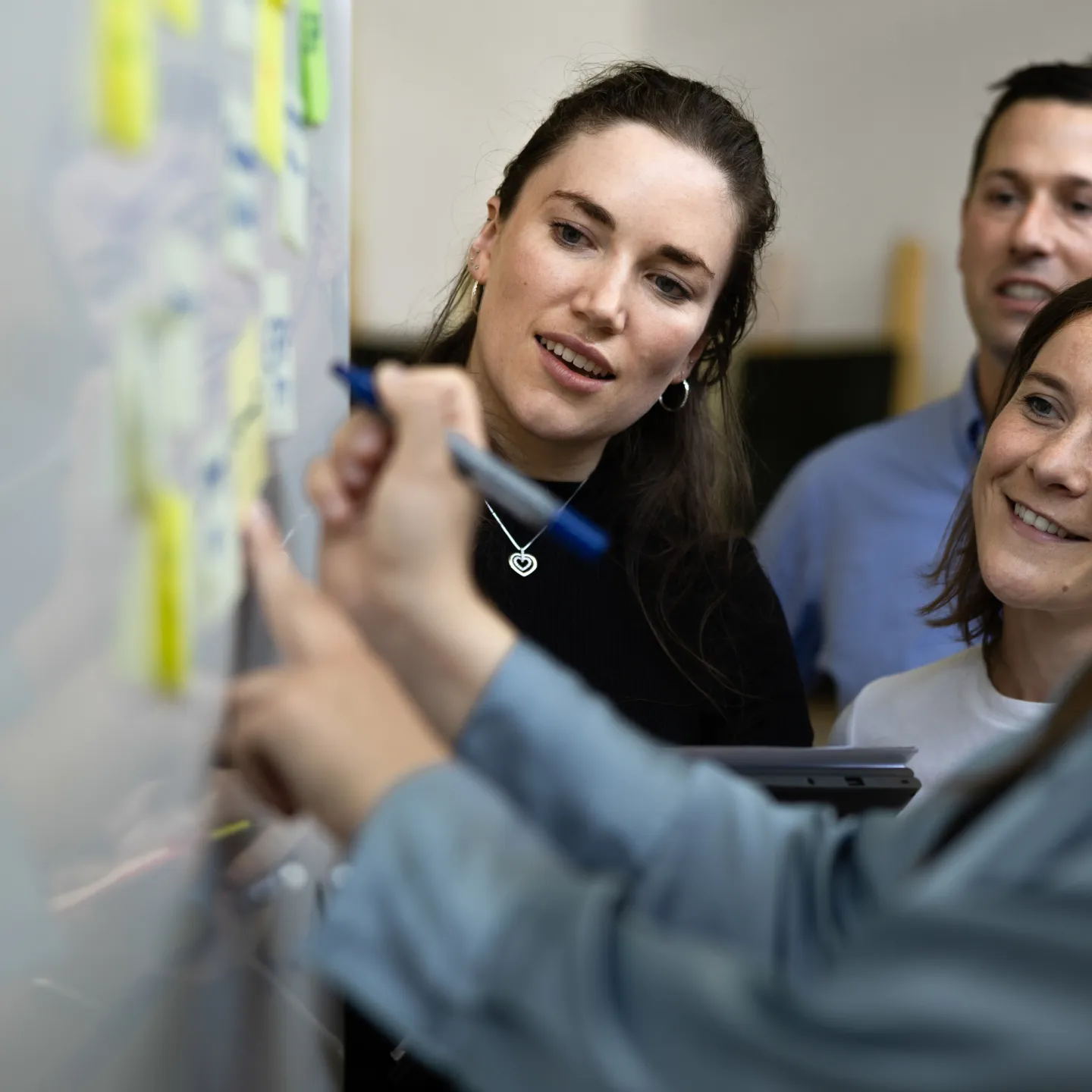 Interaktive Gruppenarbeit mit Post-its an einem Whiteboard im Seminarraum der Universität Liechtenstein.