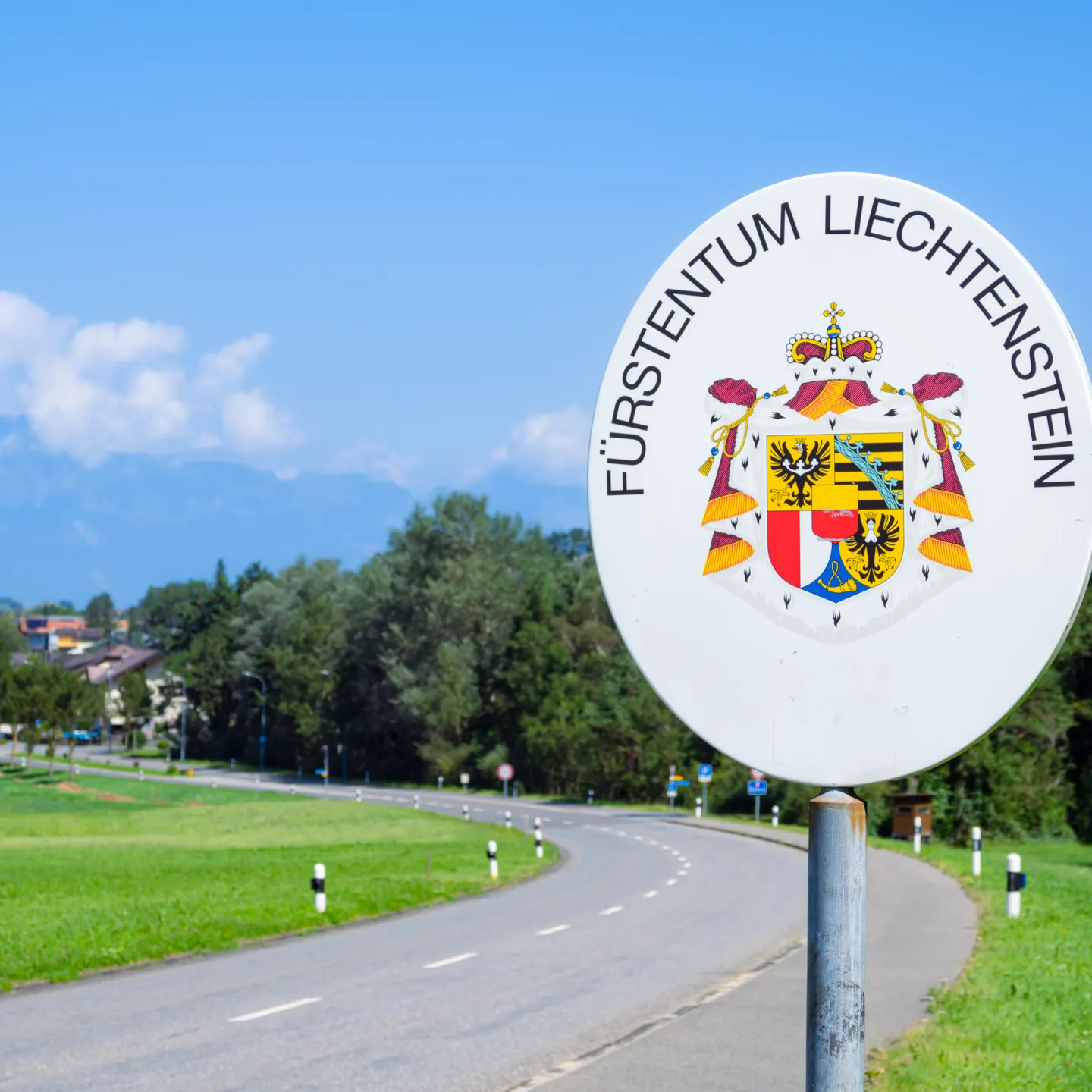 Grenzschild Fuerstentum Liechtenstein Strasse in grüner Umgebung