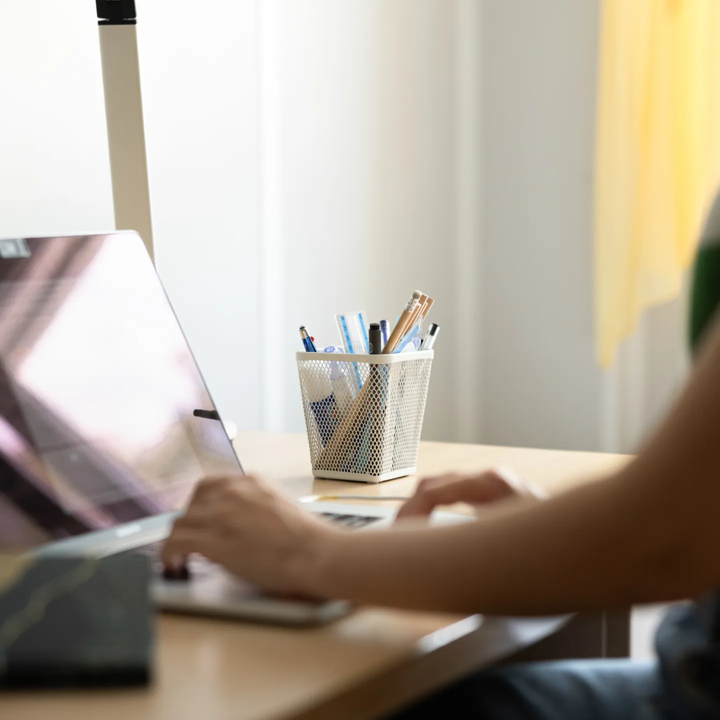 Studierende arbeitet am Laptop am Schreibtisch im Studierendenwohnheim der Universität Liechtenstein.