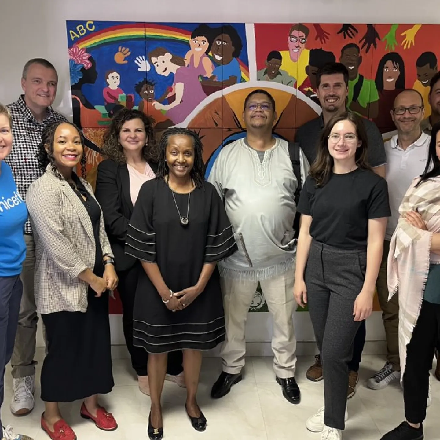 Eine Gruppe von Menschen steht lächelnd vor einem bunten Wandgemälde. Sie sind Teil einer Delegation der Universität Liechtenstein und Partnerorganisationen, die an einer Expedition nach Südafrika teilnehmen, um nachhaltige Finanzlösungen zu entwickeln.