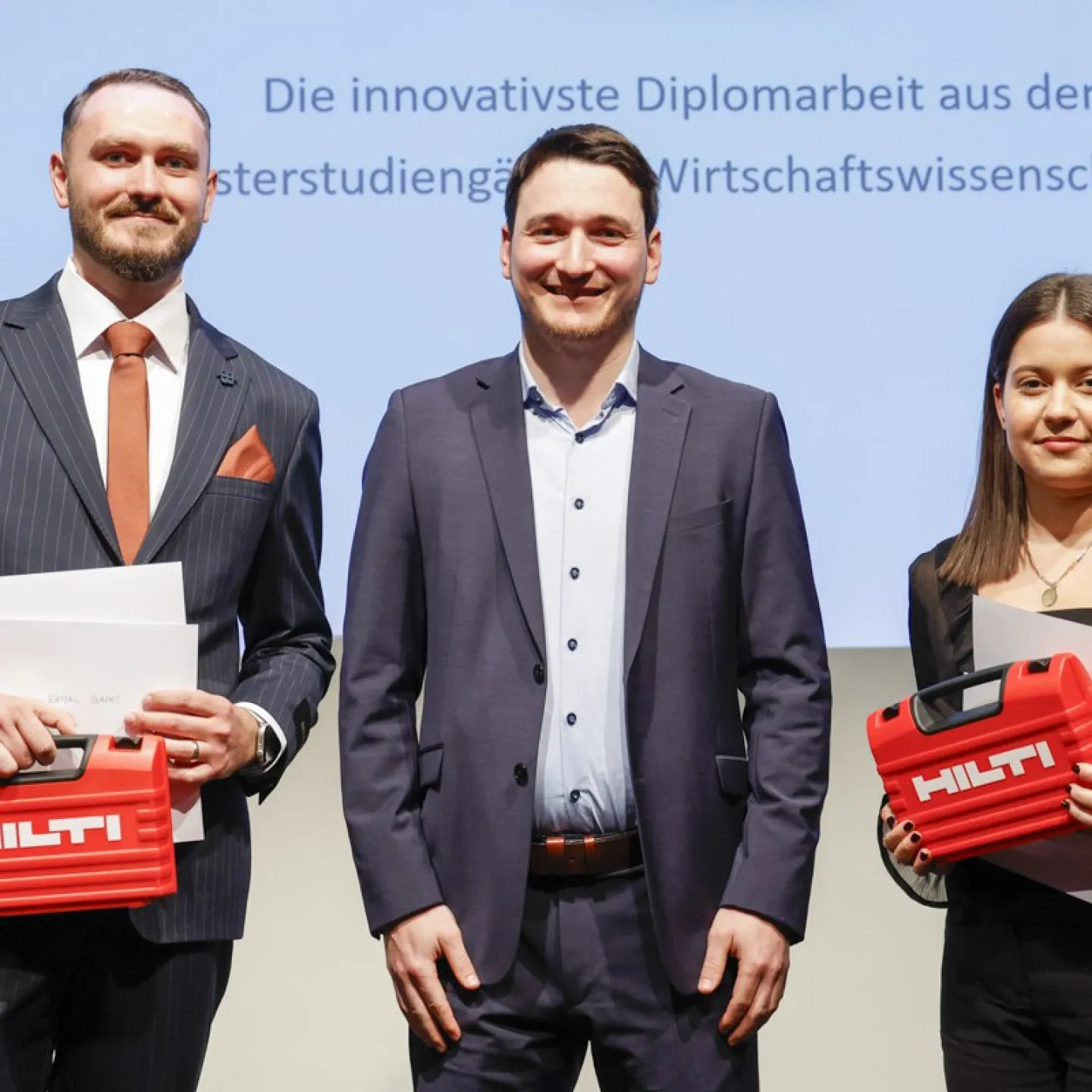 Tobias Zangerl mit Ermal Gashi und Laura Boltizar welche einen Hilti Koffer halten.