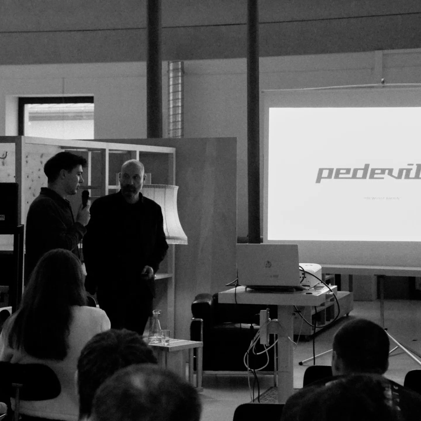 Schwarz-Weiss Aufnahme von zwei Männern mit Mikrofon 