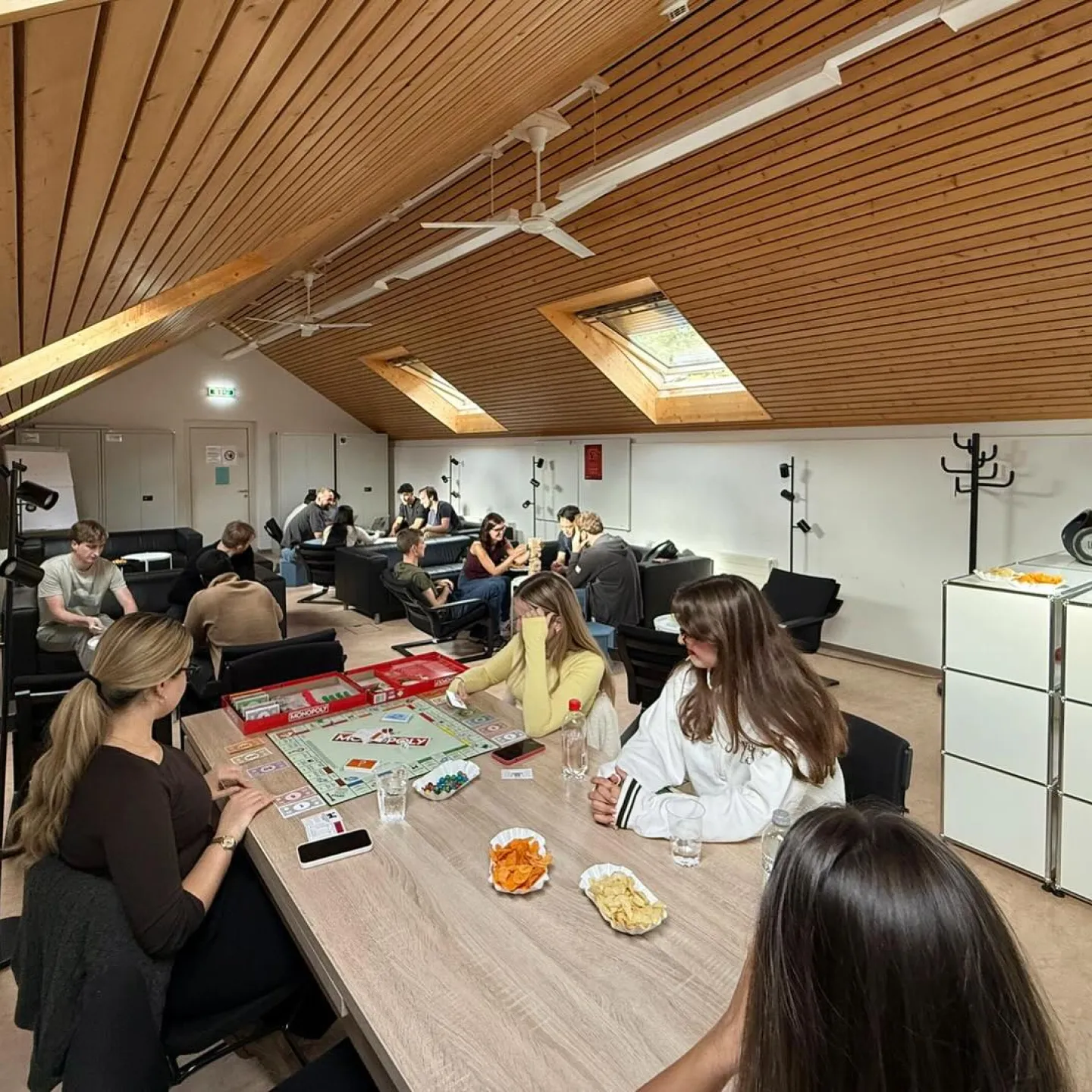 Mehrere Studierende sitzen in einem Raum und spielen