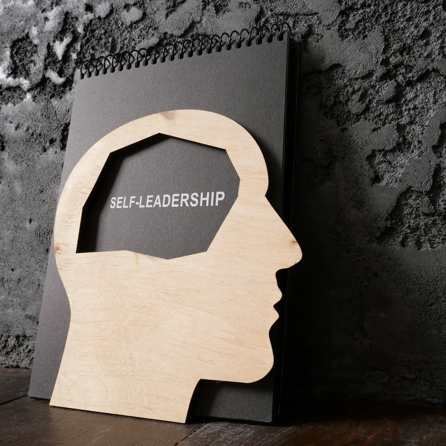 Stilisierter Kopf aus Holz mit Beschriftung Self Leadership