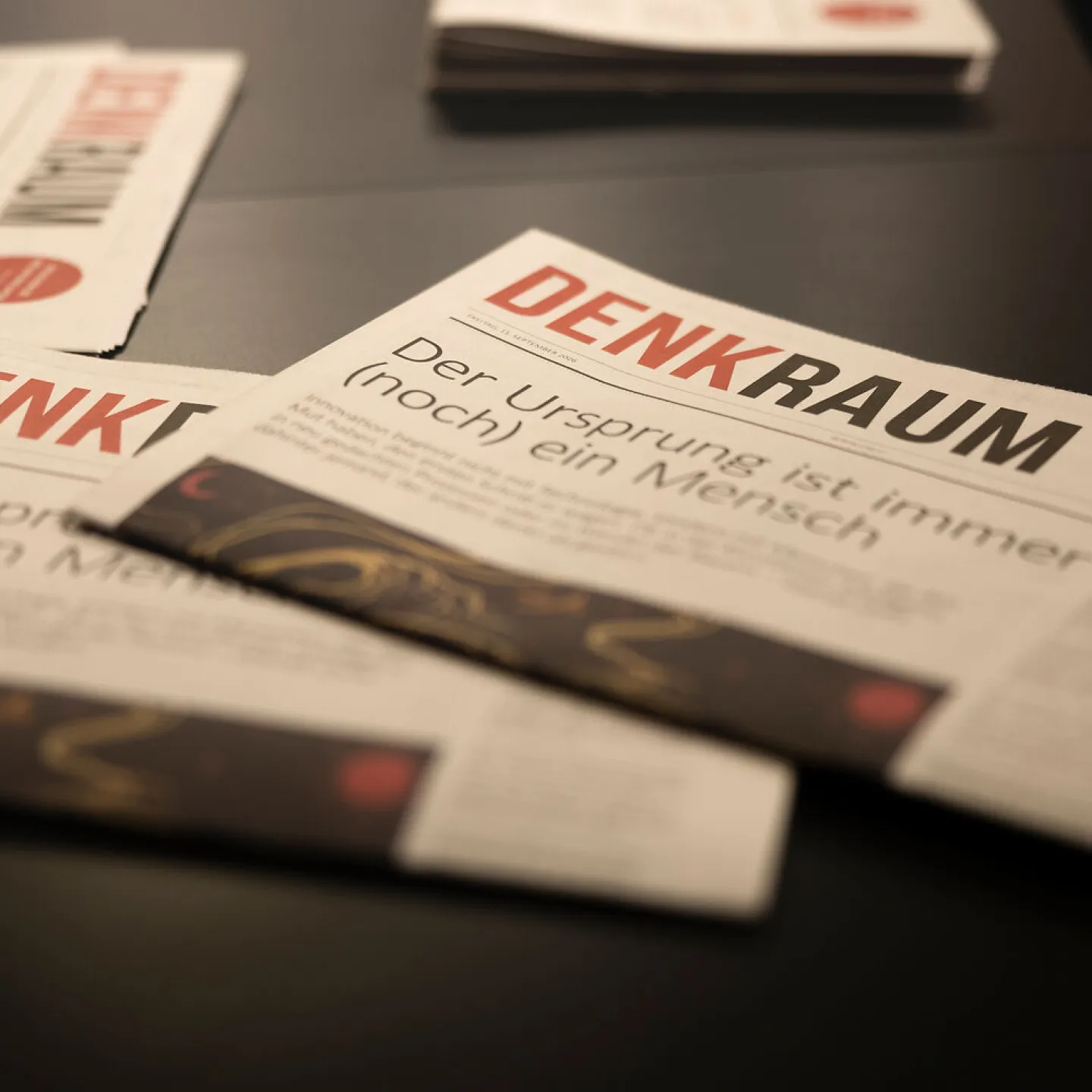 Mehrere Exemplare der Denkraum-Zeitung liegen auf dem Tisch