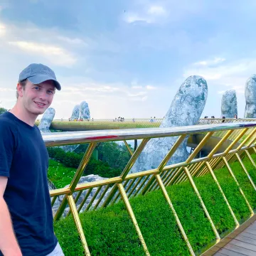 Student der Universität Liechtenstein steht auf der bekannten Golden Bridge in Vietnam während eines Auslandsaufenthalts.
