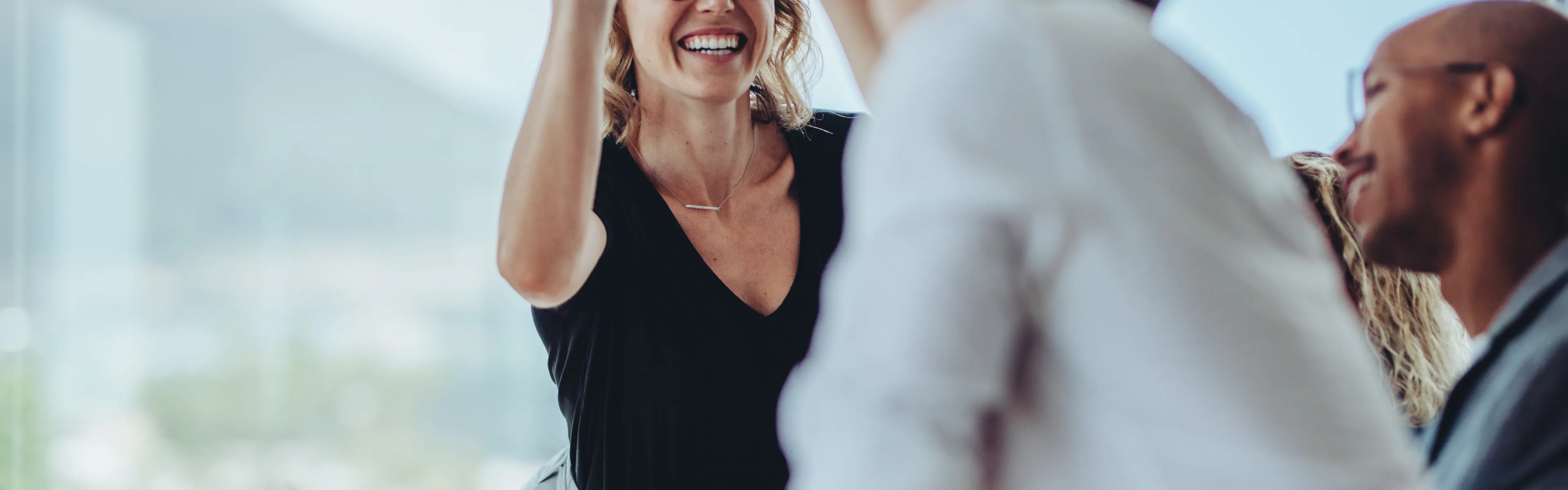 Teilnehmende einer Weiterbildung an der Universität Liechtenstein freuen sich über gemeinsame Erfolge und geben sich ein High-Five.