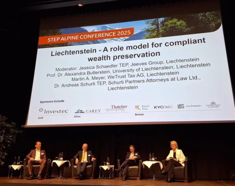 Podiumsdiskussion bei der STEP Alpine Conference 2025 mit vier Expertinnen und Experten auf einer Bühne vor einer großen Leinwand, die das Thema „Liechtenstein – A role model for compliant wealth preservation“ zeigt.