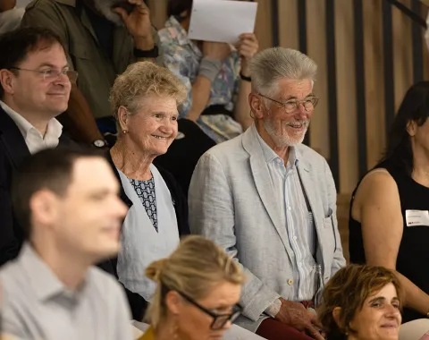 Eine Gruppe von Menschen sitzt lächelnd in einem Auditorium während des Tags der offenen Tür an der Universität Liechtenstein.