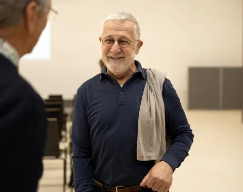 Bild von einem Mann mit grauen Haaren, Brille und blauem Pullover