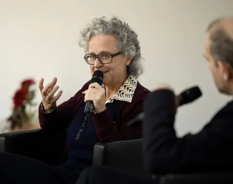 Frau mit Brille und Mikrofon bei einem Vortrag