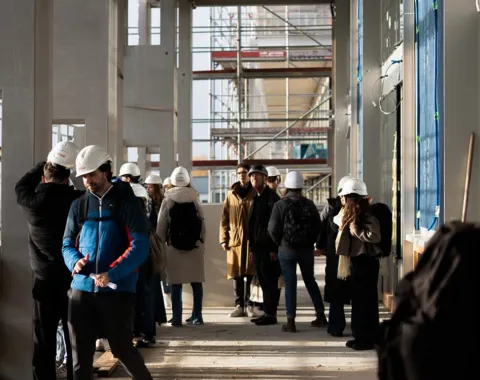 Mehrere junge Menschen mit Baustellenhelm
