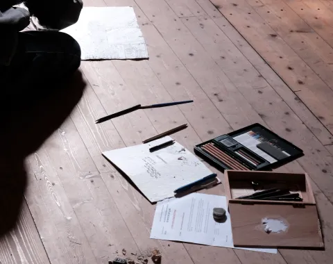 Skizzen und Farben auf einem Holzboden