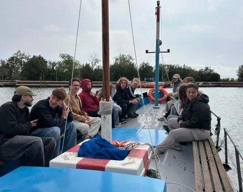Mehrere junge Menschen sitzen auf einem Segelboot