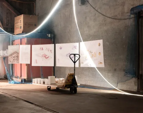 Ein Handstapler in einer Industriehalle mit aufgehängten Plänen im Hintergrund