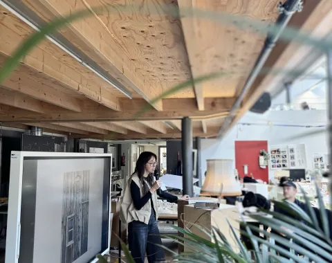 Eine Vortragende mit einer Pflanze im Vordergrund