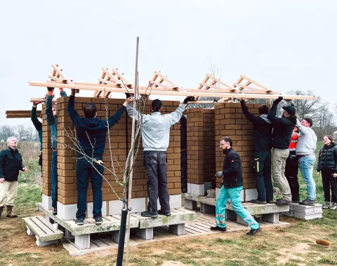 Ein kleines Gebäude aus Lehm und Holz im Bau 