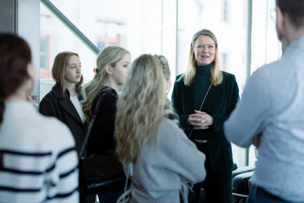 Eine Dozentin der Universität Liechtenstein spricht mit einer Gruppe interessierter Studierender bei einer Campusführung.
