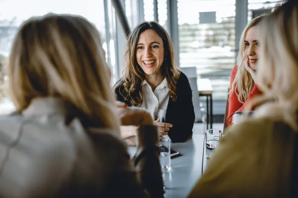 Gruppe junger Frauen im Gespräch in der Cafeteria der Universität Liechtenstein – entspannter Austausch und lebendige Campusgemeinschaft.