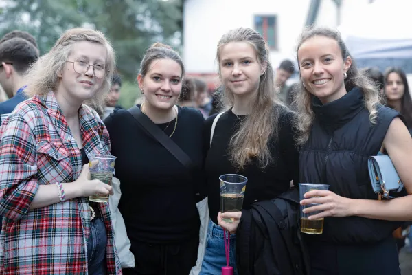 Vier Studentinnen mit Getränken bei einer Outdoor Veranstaltung auf dem Campus der Universität Liechtenstein