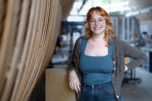 Studierende des Master Architektur der Universität Liechtenstein mit grüner Jacke steht in der Modellwerkstatt